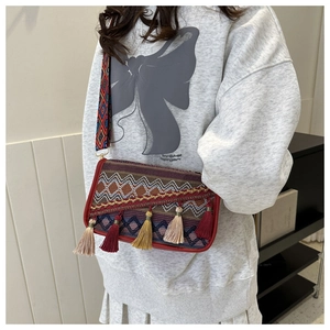 Détail d'un sac bandoulière bohème avec broderies ethniques et glands multicolores