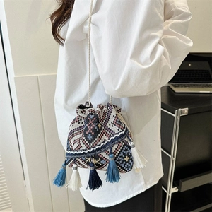 Detalle del bolso bombonera étnico con jacquard geométrico y borlas colgantes