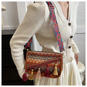 Détail du sac bandoulière bohème montrant des broderies ethniques et des pompons colorés