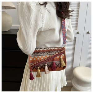 Gros plan du sac bandoulière bohème avec glands colorés et sangle ethnique brodée