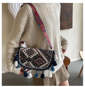 Détail d'un sac bandoulière ethnique avec motif géométrique tissé et glands colorés