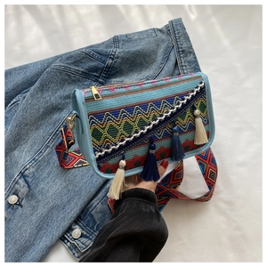 Gros plan du sac bandoulière ethnique avec motifs brodés géométriques et détails glands