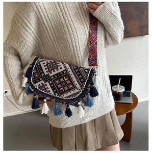 Détail du sac bandoulière bohème avec broderie ethnique et pompons colorés