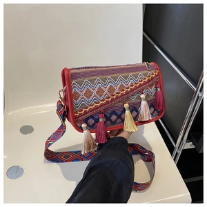 Détail du sac à bandoulière ethnique avec broderie géométrique et pompons colorés