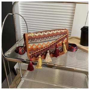 Détail du tissage jacquard bohème et des longs pompons colorés sur le sac ethnique
