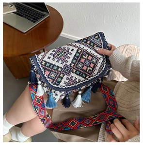 Gros plan d'un sac bohème tissé avec broderie colorée et détails de pompons