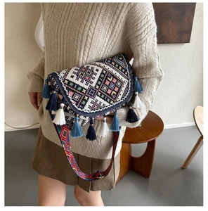 Détail d'un sac bandoulière ethnique tissé avec des glands colorés et une sangle jacquard