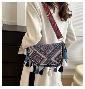 Détail du sac bohème avec broderie géométrique et franges de pompons colorés