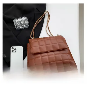 Gros plan d'un sac cabas marron matelassé avec chaîne dorée et coutures en losange