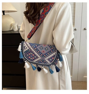 Gros plan du sac bandoulière bohème avec pompons colorés et motifs géométriques tissés