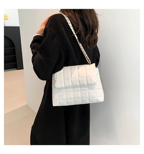 Détail du sac à bandoulière en PU matelassé blanc avec chaîne dorée porté par un mannequin