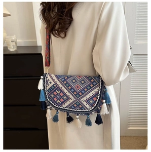 Détail d'un sac bandoulière tissé ethnique avec motifs géométriques et longues franges