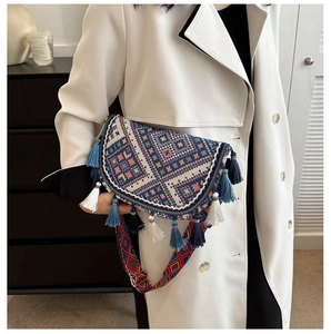 Détail d'un sac bandoulière tissé de style ethnique avec glands colorés et sangle