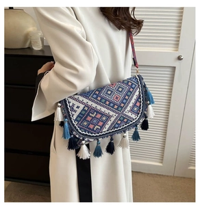 Détail d'un sac bohème avec motif géométrique bleu et ornements de pompons