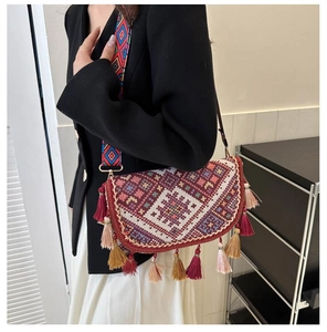 Gros plan d'un sac bandoulière bohème tissé avec motifs géométriques colorés et longues franges