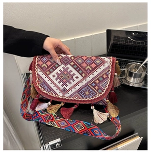 Détail d'un sac bohème tissé avec des franges colorées et une bandoulière géométrique