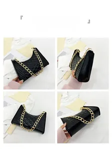 Detail view of black quilted crescent bag with chunky gold chain strap and sleek texture