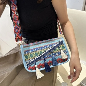 Sac bandoulière ethnique avec broderies et pompons colorés pour un style bohème