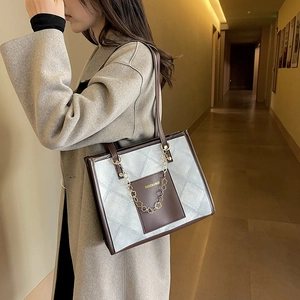 Quilted blue tote bag with brown leather pockets and gold chain strap for women