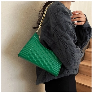 Detail of bright green crescent underarm bag with quilted texture and gold chain strap