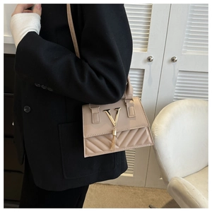 Dettaglio borsa beige con logo a V dorato ed elegante nappa con frange decorative