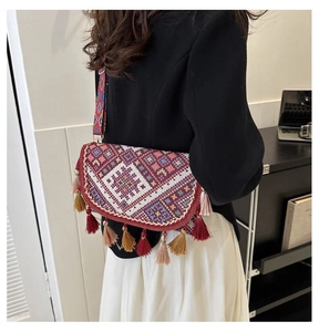 Détail du sac bandoulière en tricot bohème avec motifs ethniques et glands colorés