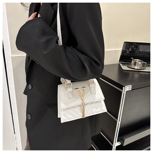 Borsa a tracolla bianca in pelle trapuntata con logo V dorato e nappina indossata da modella