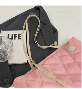 Detail der rosa gesteppten Tragetasche mit cremefarbenen Griffen und Life-Buch