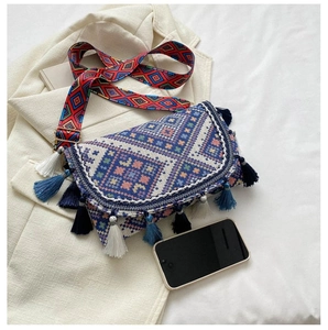 Détail du sac tissé bohème avec motifs ethniques, longues franges et large bandoulière