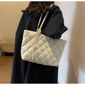 Detailaufnahme der gesteppten Puffer-Tasche in Creme mit eleganter Rautensteppung-Struktur
