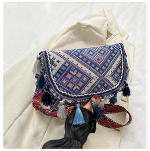 Détail d'un sac bandoulière ethnique tissé coloré avec des glands et motifs géométriques