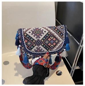 Détail d'un sac ethnique tissé avec motifs géométriques, franges et bandoulière colorée