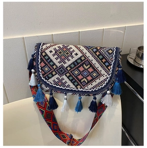 Détail d'un sac besace bohème en jacquard avec des franges colorées et une bandoulière large