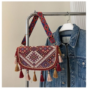 Détail d'un sac à bandoulière tissé bohème avec franges colorées et motifs ethniques