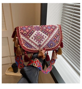 Gros plan sur un sac bohème avec broderies géométriques colorées et pompons