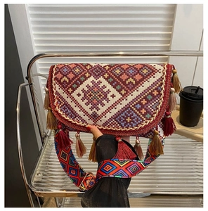Détail de broderie et pompons sur un sac à bandoulière bohème pour femme élégant