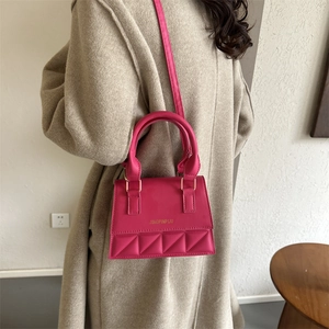 Magenta quilted crossbody bag with top handle and gold lettering for women