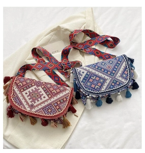 Détail du sac bandoulière ethnique avec broderie géométrique et garniture de pompons doux