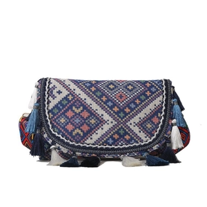 Détail d'un sac jacquard bohème avec motifs géométriques et franges à pompons colorés