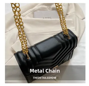 Close-up of golden chain metal connector on black quilted leather crossbody bag