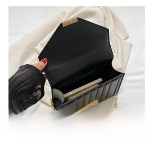 Detail view of the black quilted crossbody bag interior holding a phone and wallet