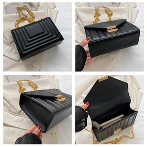 Detail view of black quilted crossbody bag with gold chain strap and metal clasp