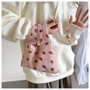 Close-up of pink corduroy tote bag with red strawberry pattern and textured fabric