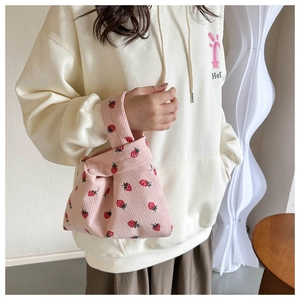 Detailed texture of pink corduroy tote bag featuring realistic strawberry prints