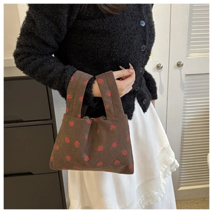 Close-up of brown corduroy tote bag featuring sweet red strawberry patterns and texture