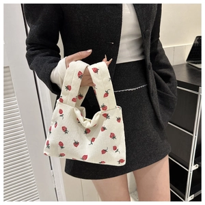 Detail of white corduroy tote bag with strawberry pattern and fine ribbed texture