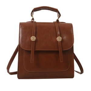 Vintage brown leather backpack with buckle straps and round metal hardware on white background