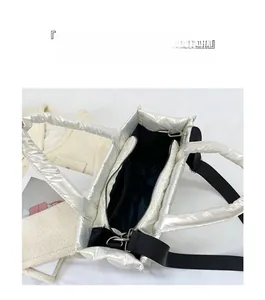 Detail view of large capacity silver quilted tote bag interior and adjustable strap