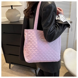 Detailed view of lavender quilted tote bag with light purple stitching and fashion label