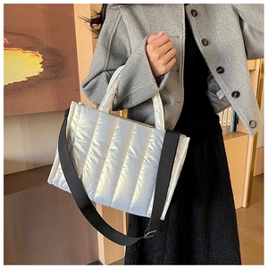 Close-up of silver quilted space cotton tote bag with metallic sheen and wide nylon strap